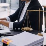 An estate planning lawyer drafting documents for a client on his laptop.