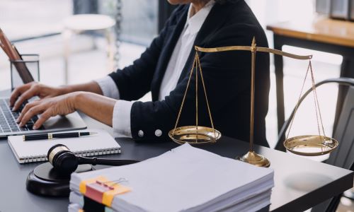 An estate planning lawyer drafting documents for a client on his laptop.