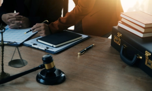 A charitable planning lawyer assisting a client with papers at a desk.
