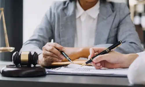 Dementia planning lawyer advising a client at a desk with legal documents, a gavel, and scales of justice