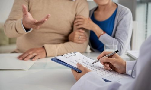 An elderly couple is discussing their health conditions with a medical practitioner.