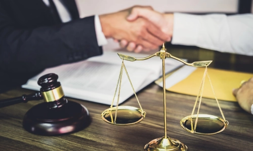 A New Jersey estate planning attorney shaking a client's hand when they meet in an office.