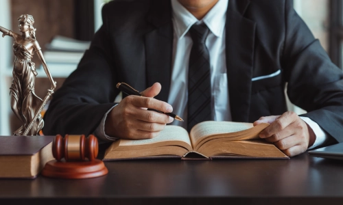 A New Jersey Medicaid planning lawyer sits behind an office desk while reading through a law book