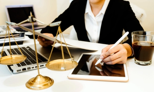 A New Jersey Medicaid planning lawyer writes on a tablet with a stylus while holding a document in her other hand