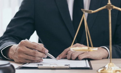 A New Jersey Medicaid planning attorney notarizes documents while sitting at a desk in their law office