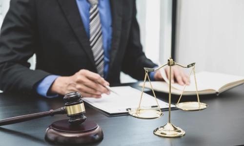 A New Jersey Medicaid planning attorney checks his notes against documents on a clipboard while sitting in a law office