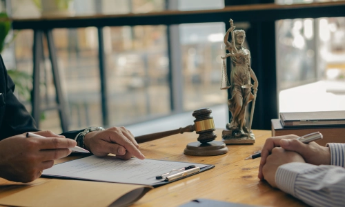 A Bridgewater trusts and estates lawyer pointing to a document while explaining the contents to a client sitting on the opposite side of a table