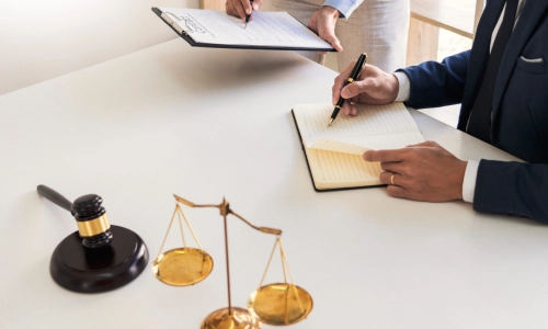 A pair of Rocky Hill trusts and estates lawyers comparing notes to legal documents and discussing case details in a law office