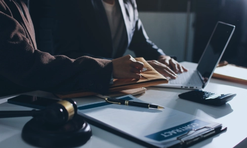 A Sommerset County trusts and estates lawyer is opening an envelope with a colleague who is working on a laptop as they sit next to each other