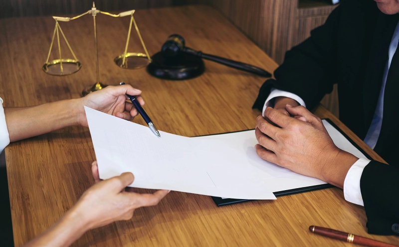 A trusts lawyer discussing the contents of a legal trust document to a client sitting across a table