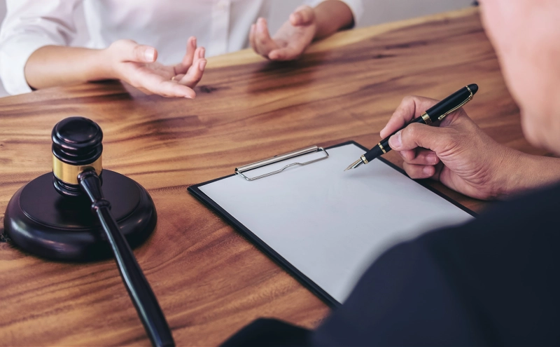 A man consulting with a wills and trusts attorney regarding the cost of drafting a will for his estate.