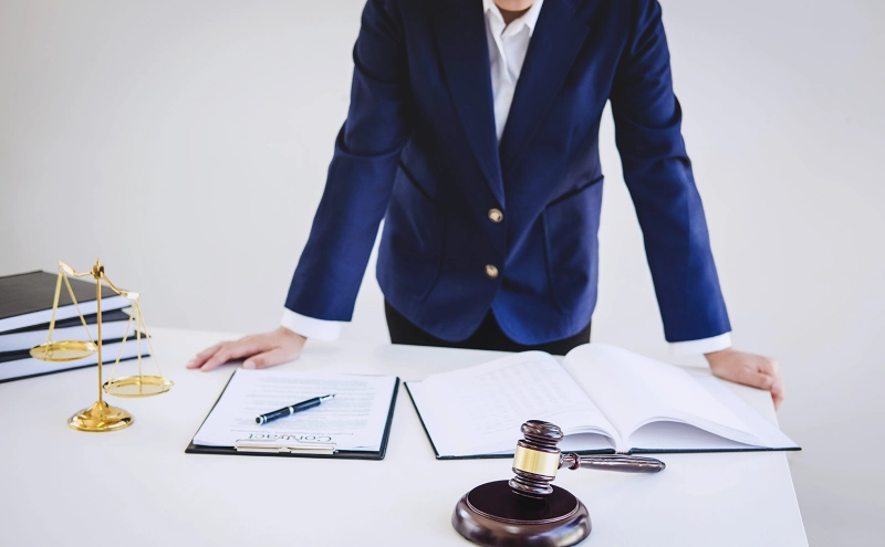 An elder law lawyer leaning on a table and reviewing a documents while preparing to secure a Medicaid waiver.