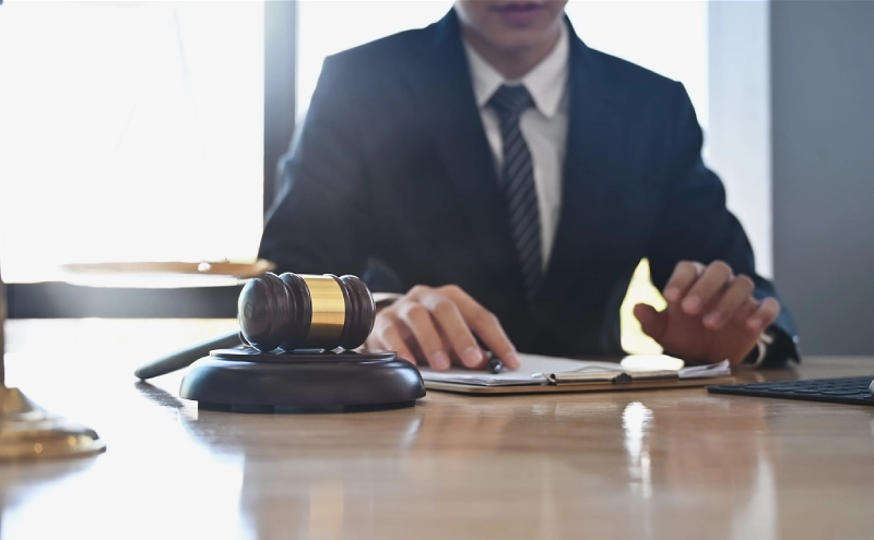An asset protection attorney in his office reviewing a clipboard to present to a client.