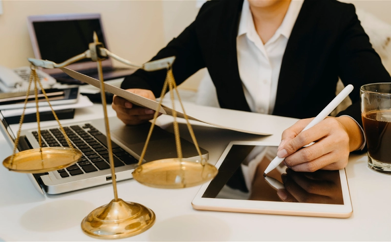 An estate planning lawyer in an office working on property transfer for a client over a tablet.