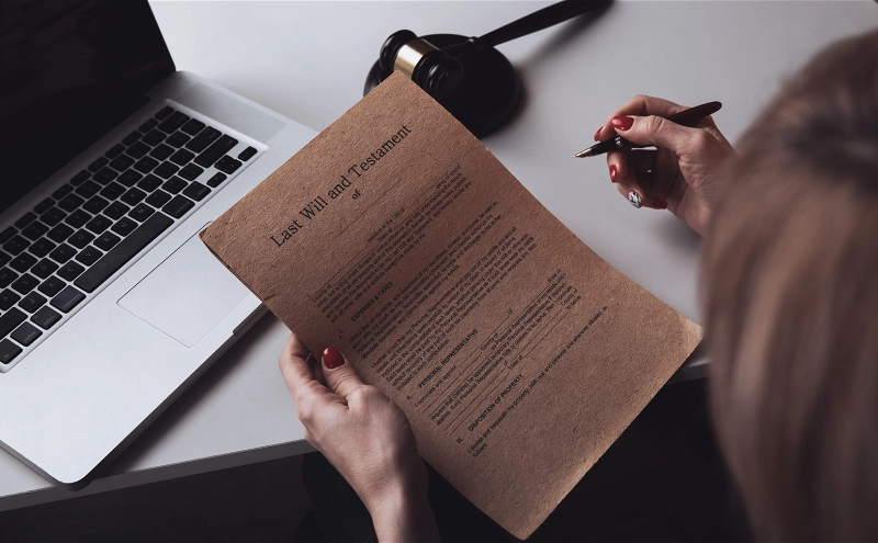 An estate planning lawyer holding a pen while reading the last will and testament of a client.