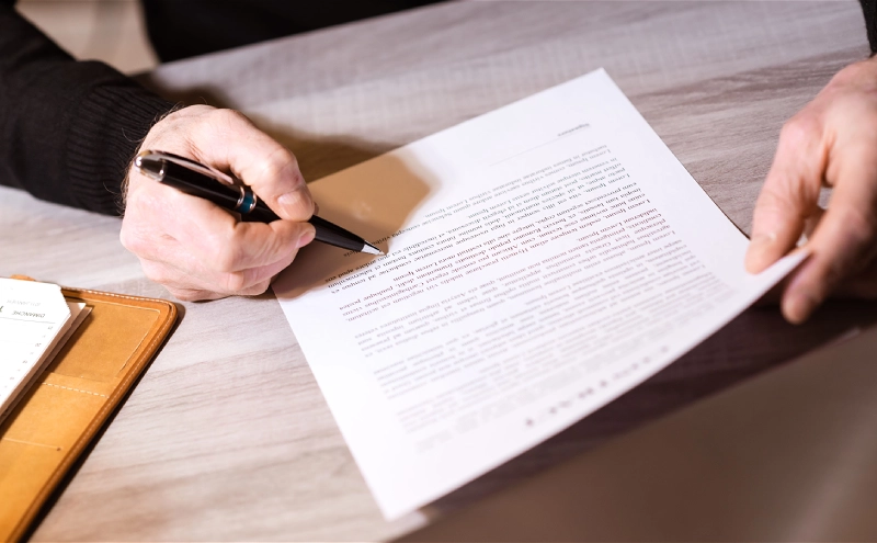 An overhead shot of a trusts lawyer presenting a rough draft of a client's trust to them.